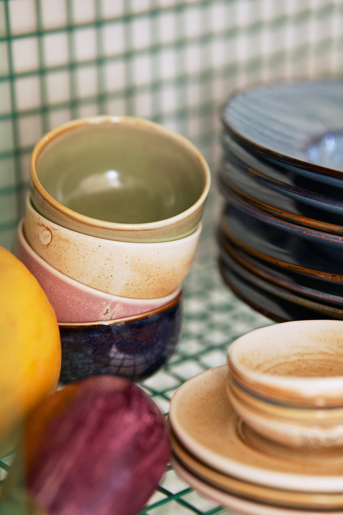 close up of stack of 4 porcelain bowls in green, cream pink and blue colors