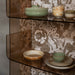 retro wall paper and moss green and cream brown chef ceramics in open shelving