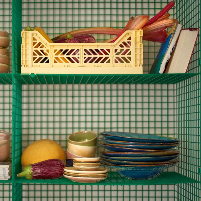 green shelving with colored ceramics and produce