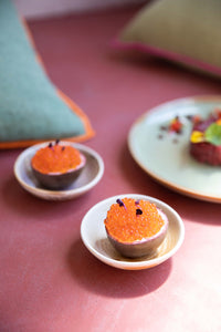 pink table top with cream brown small dishes filled with fruit