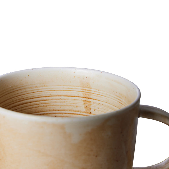 detail of cream and brown rustic coffee mug with ear
