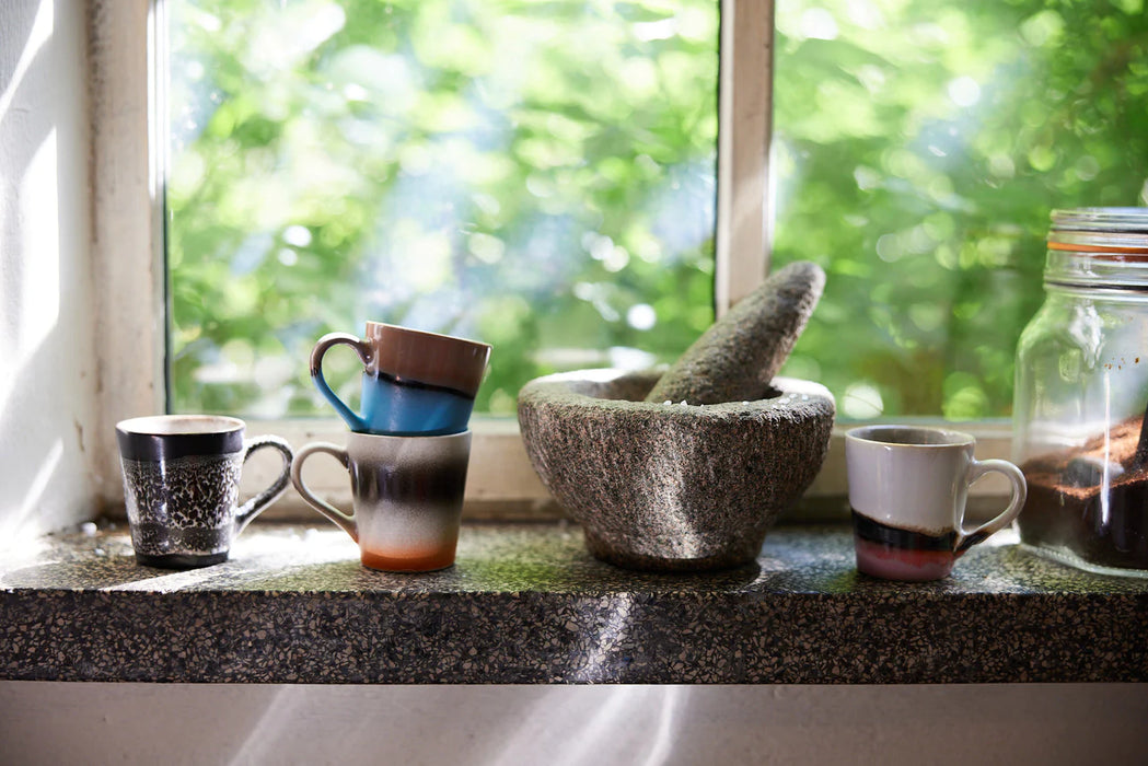 4 different colored retro style espresso cups with ear in a kitchen window