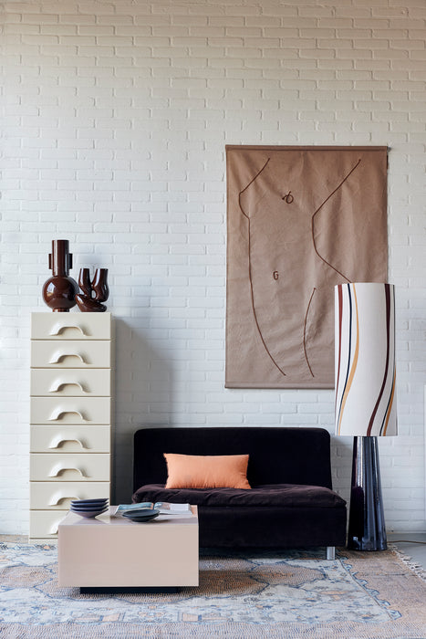 drawer with espresso brown colored vases, wall hanging and large floor lamp in a living room