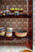 4 retro style dessert bowls with reactive glaze finish in a smoky brown colored open shelving cabinet