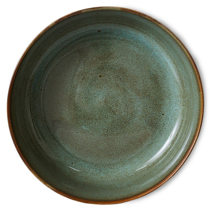 large round ceramic serving bowl in brown hues with green inside