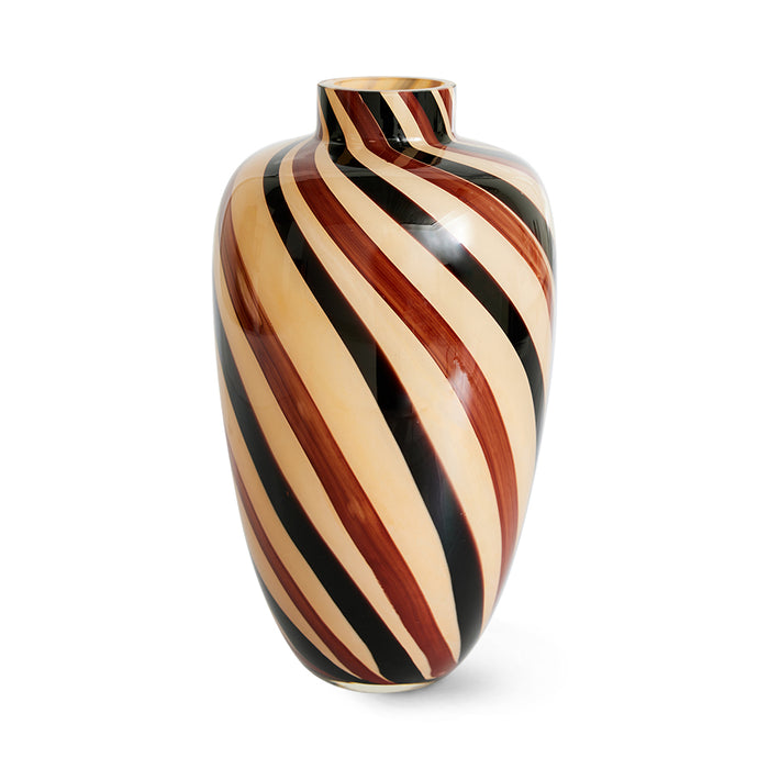 swirled glass vase in sand, and brown tones