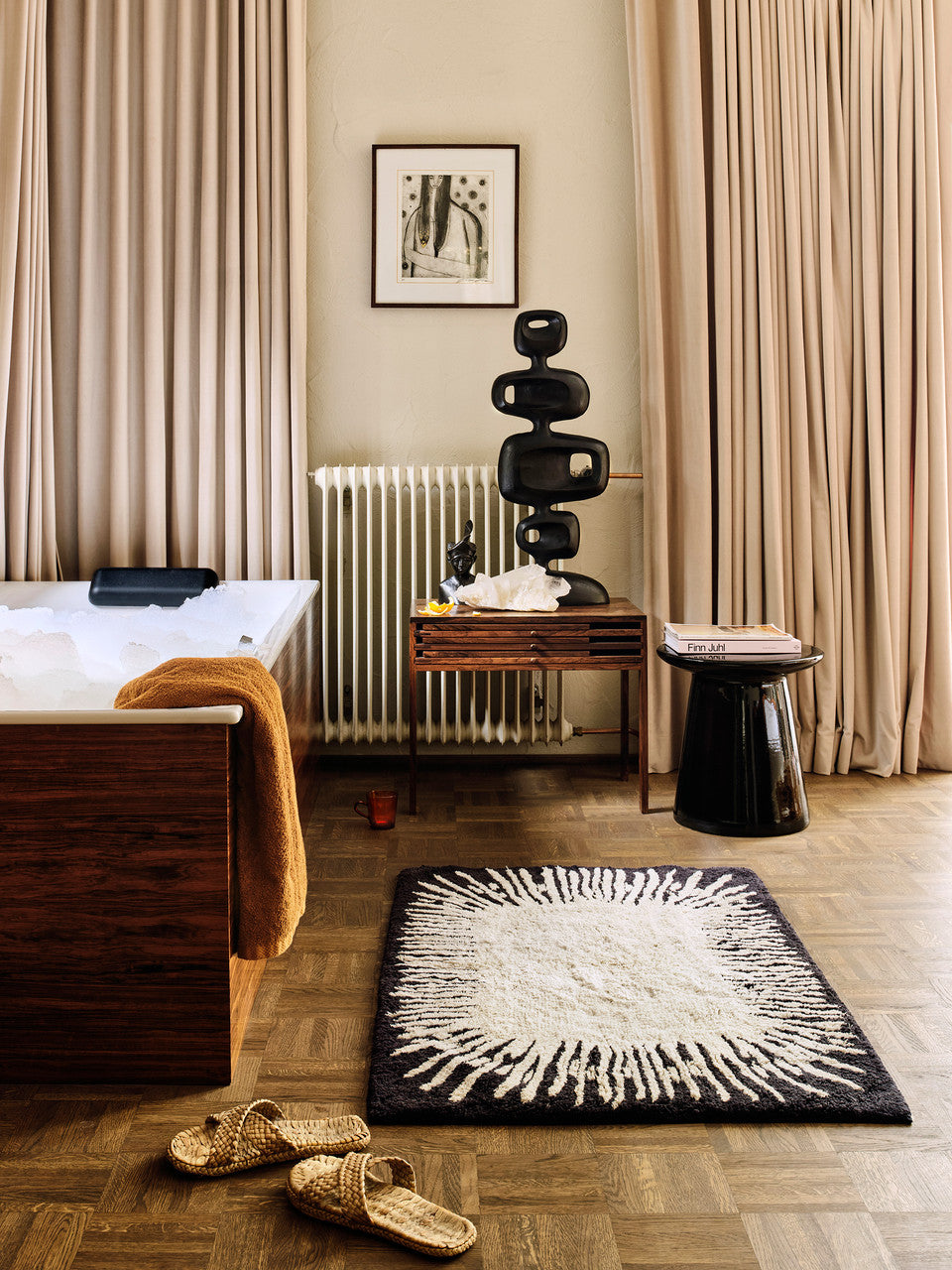 monochrome bathroom with black earthenware side table and sculpture