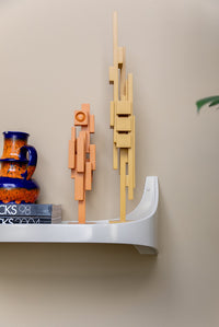 two wooden sculptures on a plastics shelf