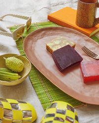 terra oval serving platter on a green runner with fruit and candy in bright colors