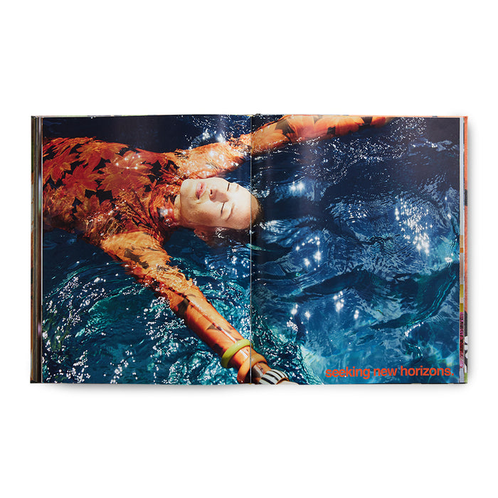 inside of look book woman in pool with orange dress