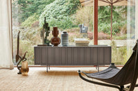 concrete grey tv stand low sideboard in front of window with sculptures and vases