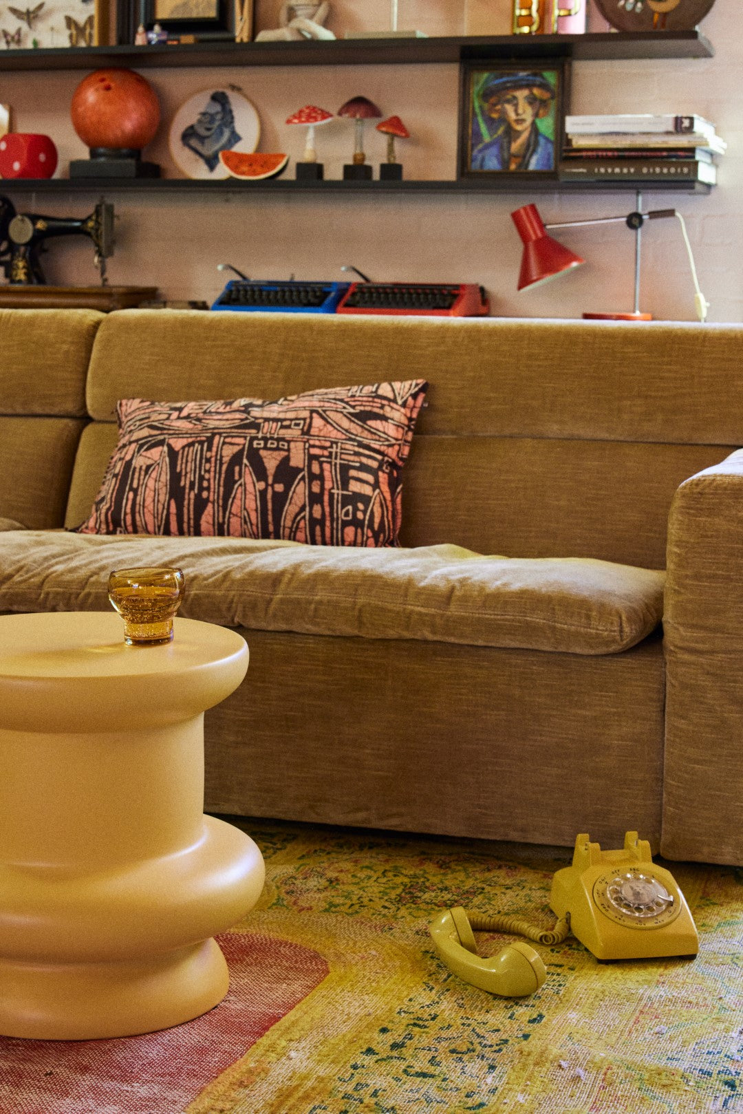 honey yellow curved earthenware accent table with brown sofa and yellow phone