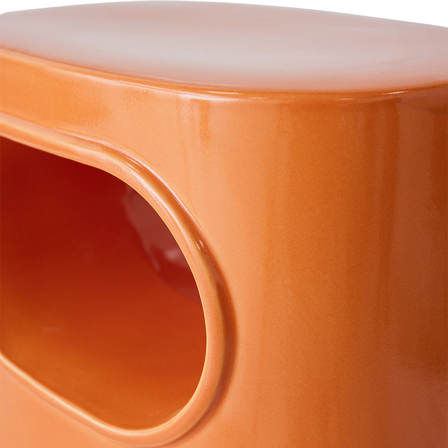 orange colored earthenware accent table with open space