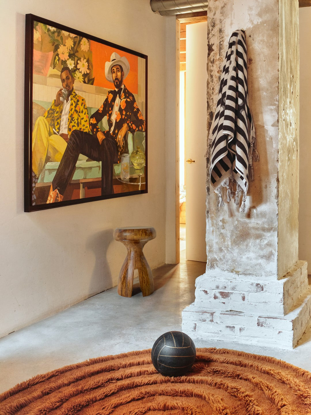 black and white towel on wall with artwork and wooden stool