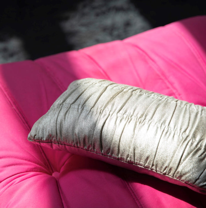 silver colored accent pillow on pink sofa