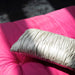 silver colored accent pillow on pink sofa