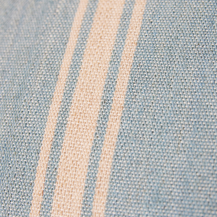 close up of double sided hand woven pillow in soft blue and light brown