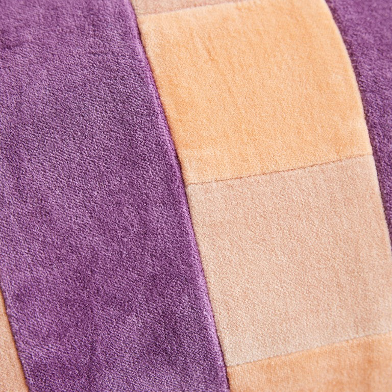 detail of velvet lumbar pillow with peach, pink and purple stripes 