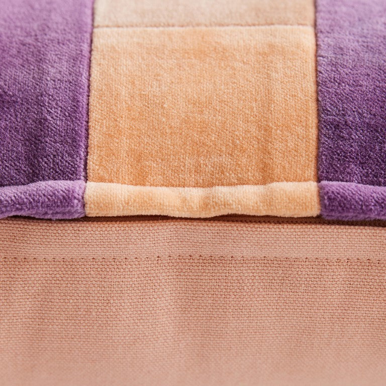 detail of velvet lumbar pillow with peach, pink and purple stripes 