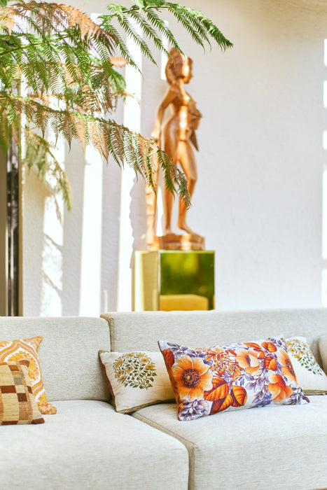 golden sculpture of woman with a sofa with lumbar pillows in different prints