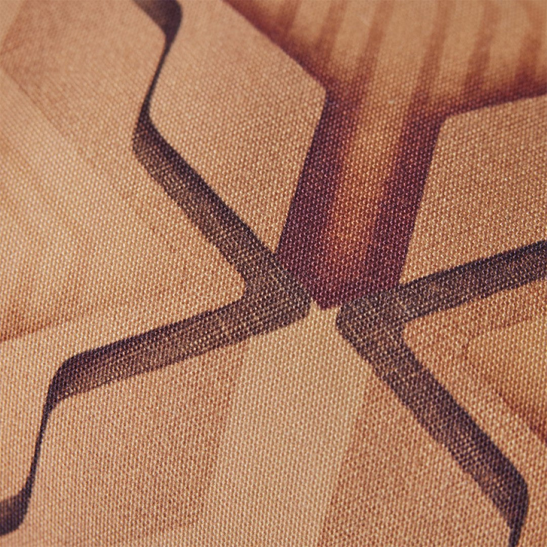 detail of fabric from retro style pillow in orange brown hues