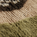 detail of eclectic asymmetrical area rug in warm earth tones