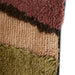 detail of eclectic asymmetrical area rug in warm earth tones