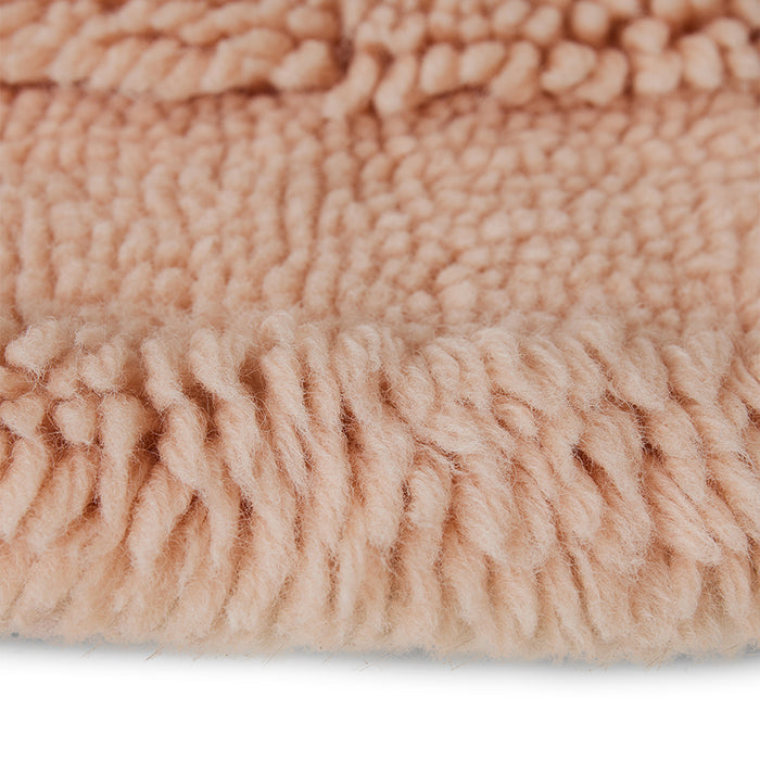 detail of round soft pink colored woolen rug