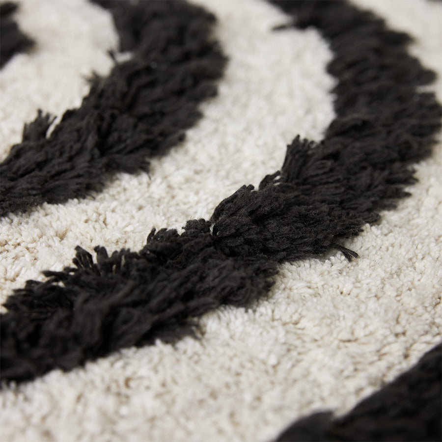 close up round black and white bathroom rug