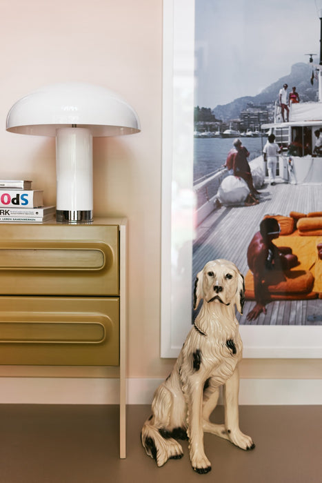 cream colored table lamp with sculpture of dog and art work