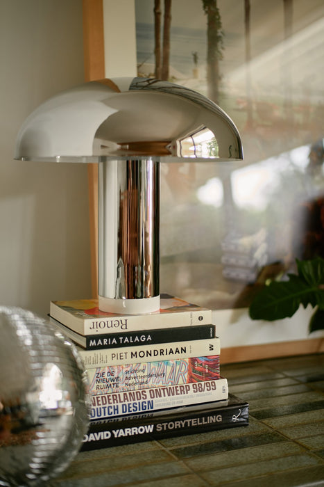 chrome table lamp on stack of books