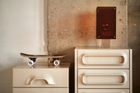 smokey brown and brass corner tale  lamp on cream colored dresser