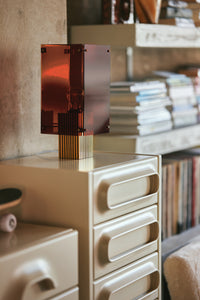 smokey brown and brass corner tale  lamp on cream colored dresser