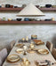 cream and brown ceramic table ware on a beige table with beige  light fixture