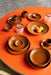 retro style burned orange porcelain tableware on orange table top