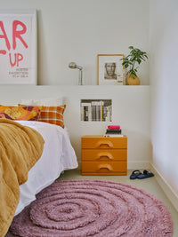 round high and low pile tufted lilac rug and orange nightstand with drawers