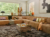 swirled glass vase in sand, and brown tones in window behind element sofa
