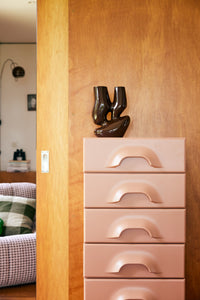 blush colored chest with 7 drawers with brown organic shaped flower vase