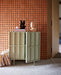 brick wall with modern credenza and two organic shaped vases