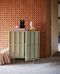 brick wall with credenza, brown colored organic shaped flower vases in hallway