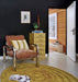 living rom with black wall, yellow round area rug and chrome and velvet lounge chair with velvet striped pillow