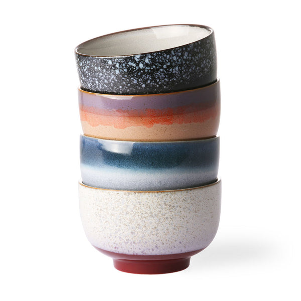Stack of three ceramic cups with multicolored glaze on a white background