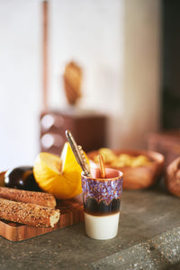 kitchen with bread on breadbord, tall tea mug with catlerly