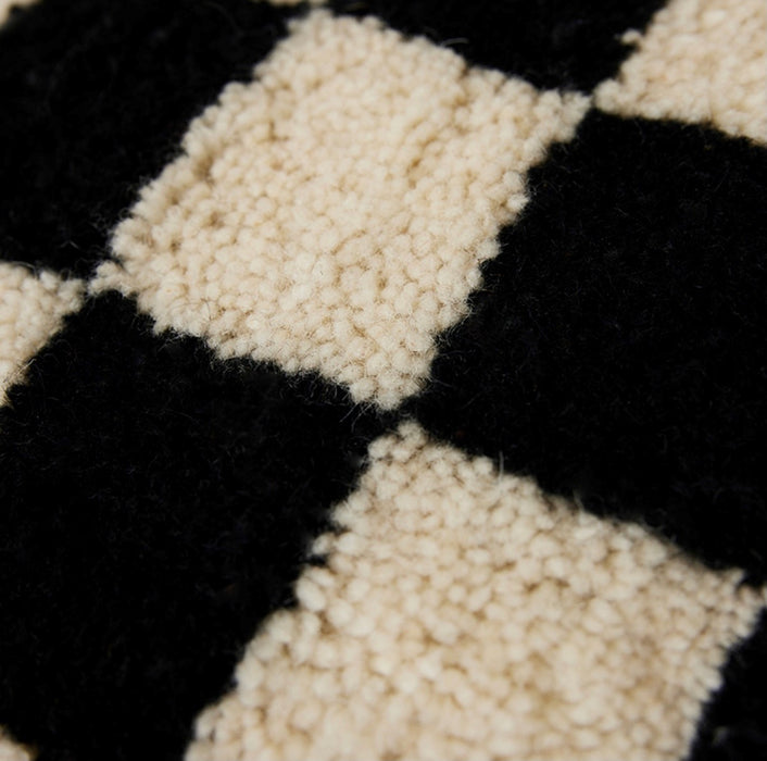 detail of black and white checkered woolen decorative pillow