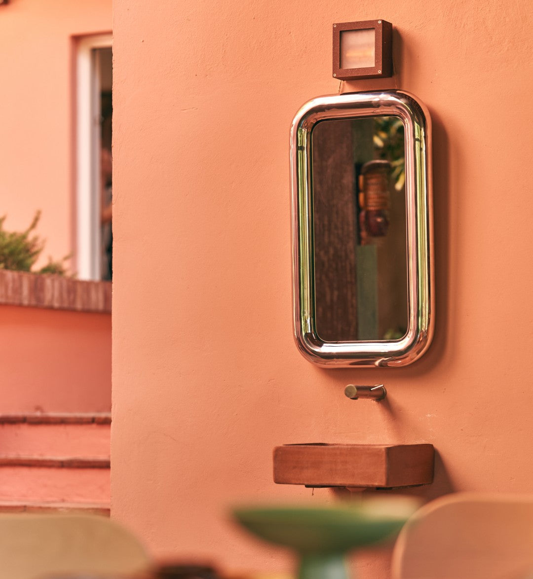 chrome mirror on terracotta color wall