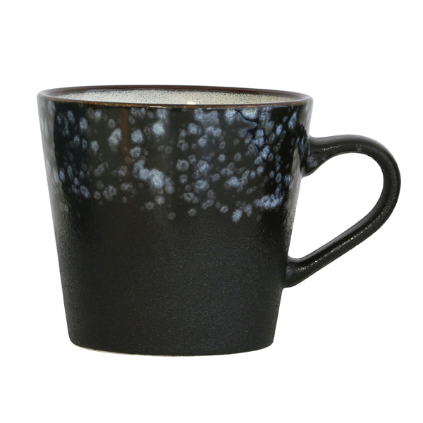 Black ceramic mug with speckled pattern on a white background