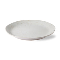 White ceramic plate with speckled texture on a white background