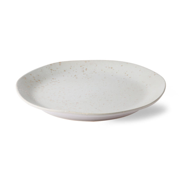 White ceramic plate with speckled texture on a white background