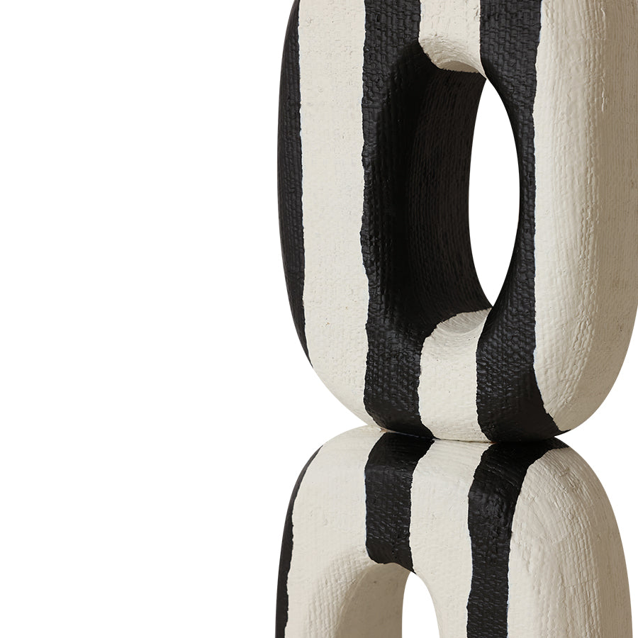 Black and white striped decorative object on a white background