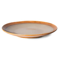 Ceramic plate with brown rim and beige center on a white background
